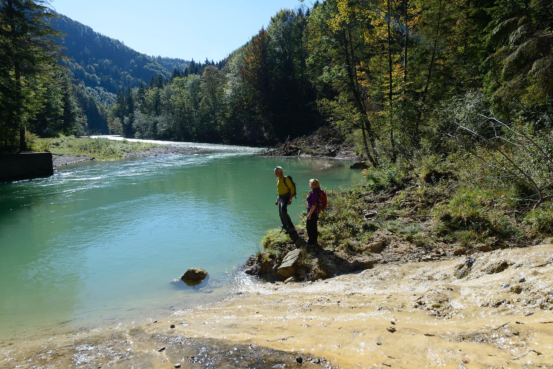 Wanderer an der Ammer mit grünem Wasser im Tal