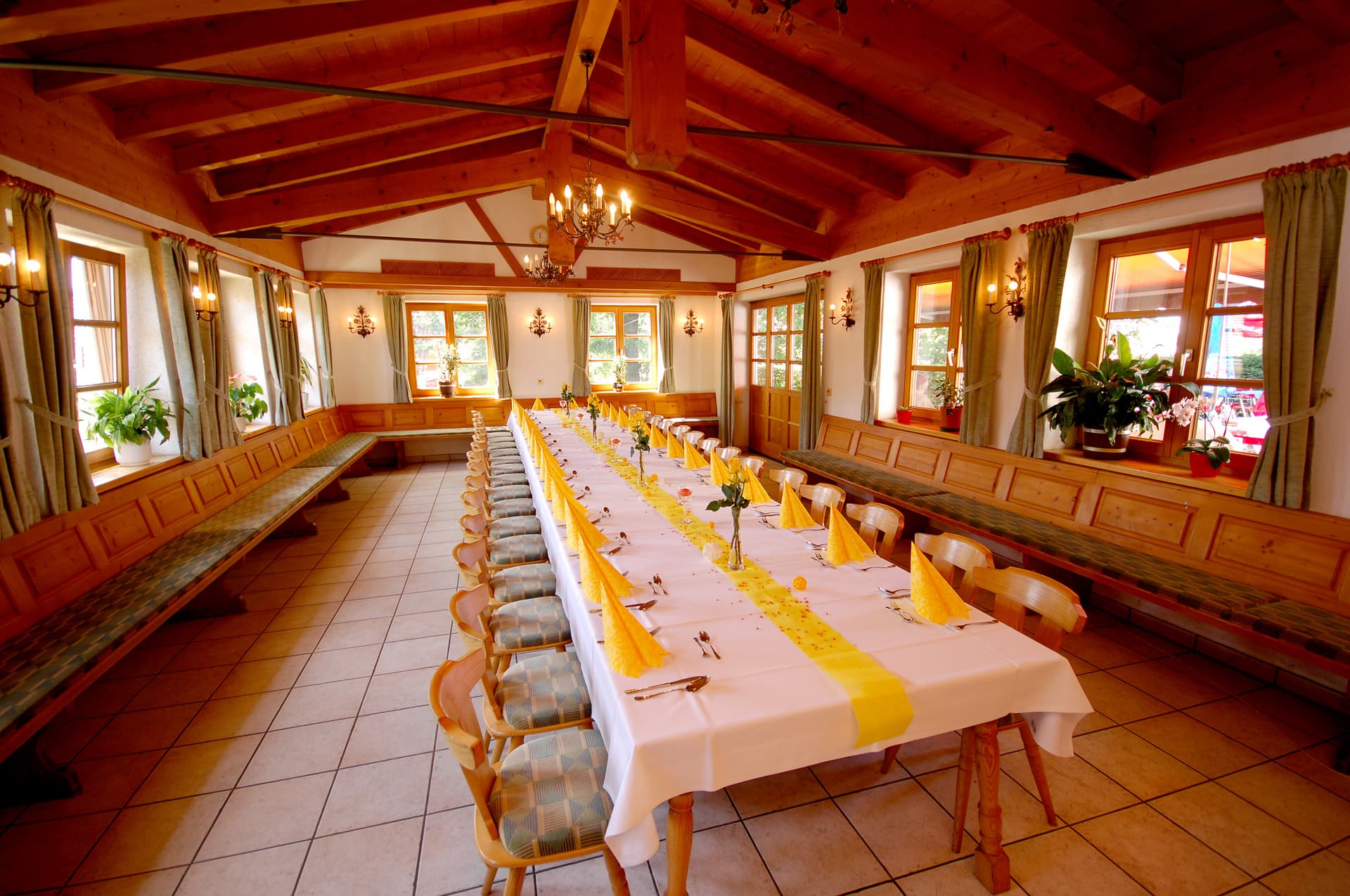 Großer Saal mit langer, festlich gedeckter Tafel in Gelb