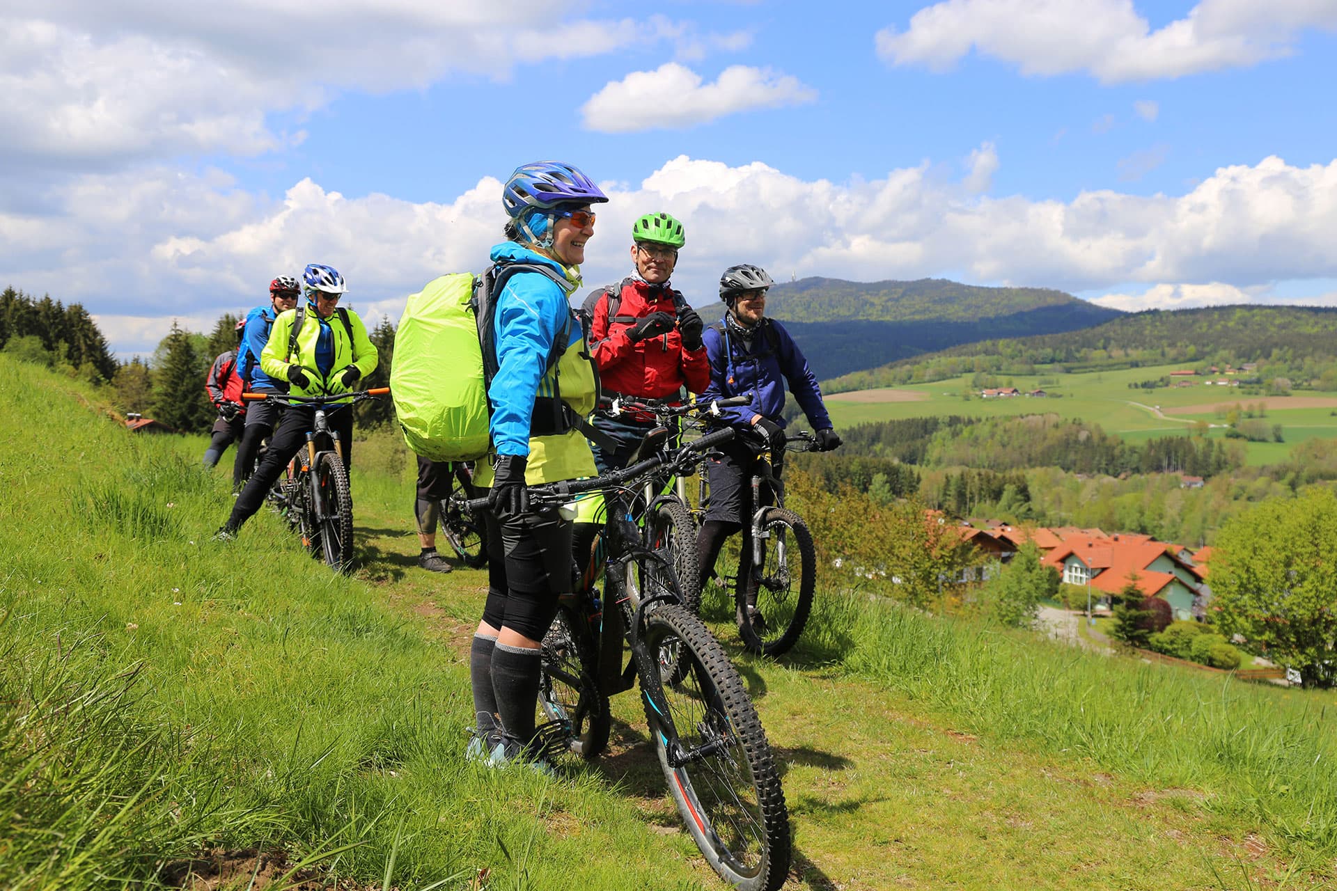 Gruppe von Radfahrern mit Mountainbikes auf einer Wiese im Pfaffenwinkel
