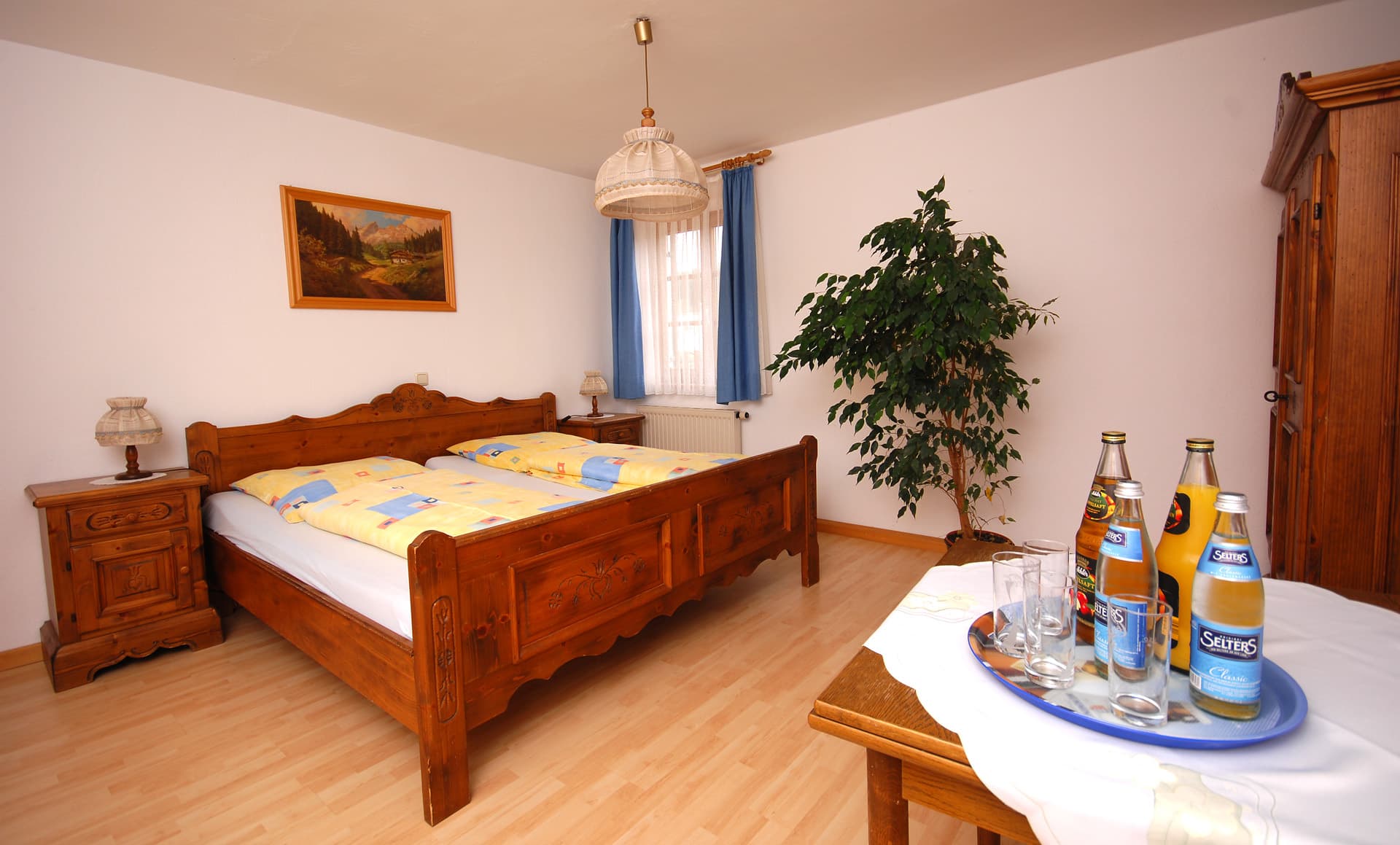 Gästezimmer mit Doppelbett aus Holz und Nachttisch